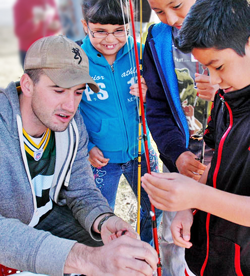 Become a Wildlife Conservation Volunteer. (Photo of fishing instructor helping youth). New Mexico Department of Game and Fish