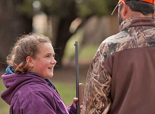 Become a Wildlife Conservation Volunteer. (Photo of hunting instructor helping youth). New Mexico Department of Game and Fish