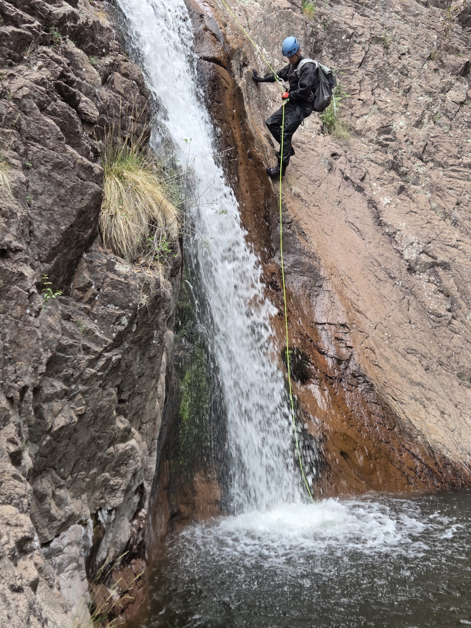 Rappelling down next to a waterfall