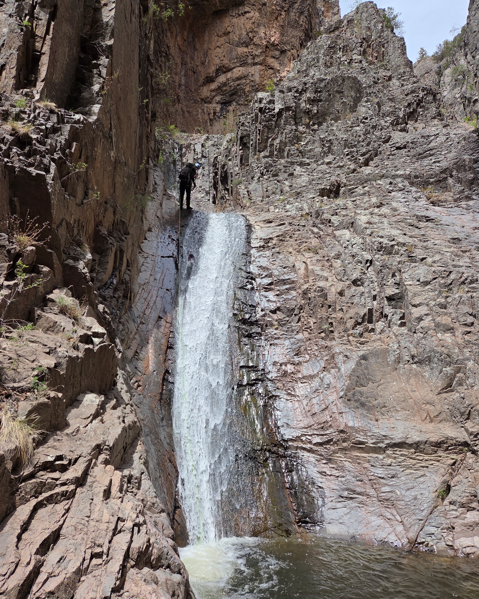 Rappelling down the top of a waterfall